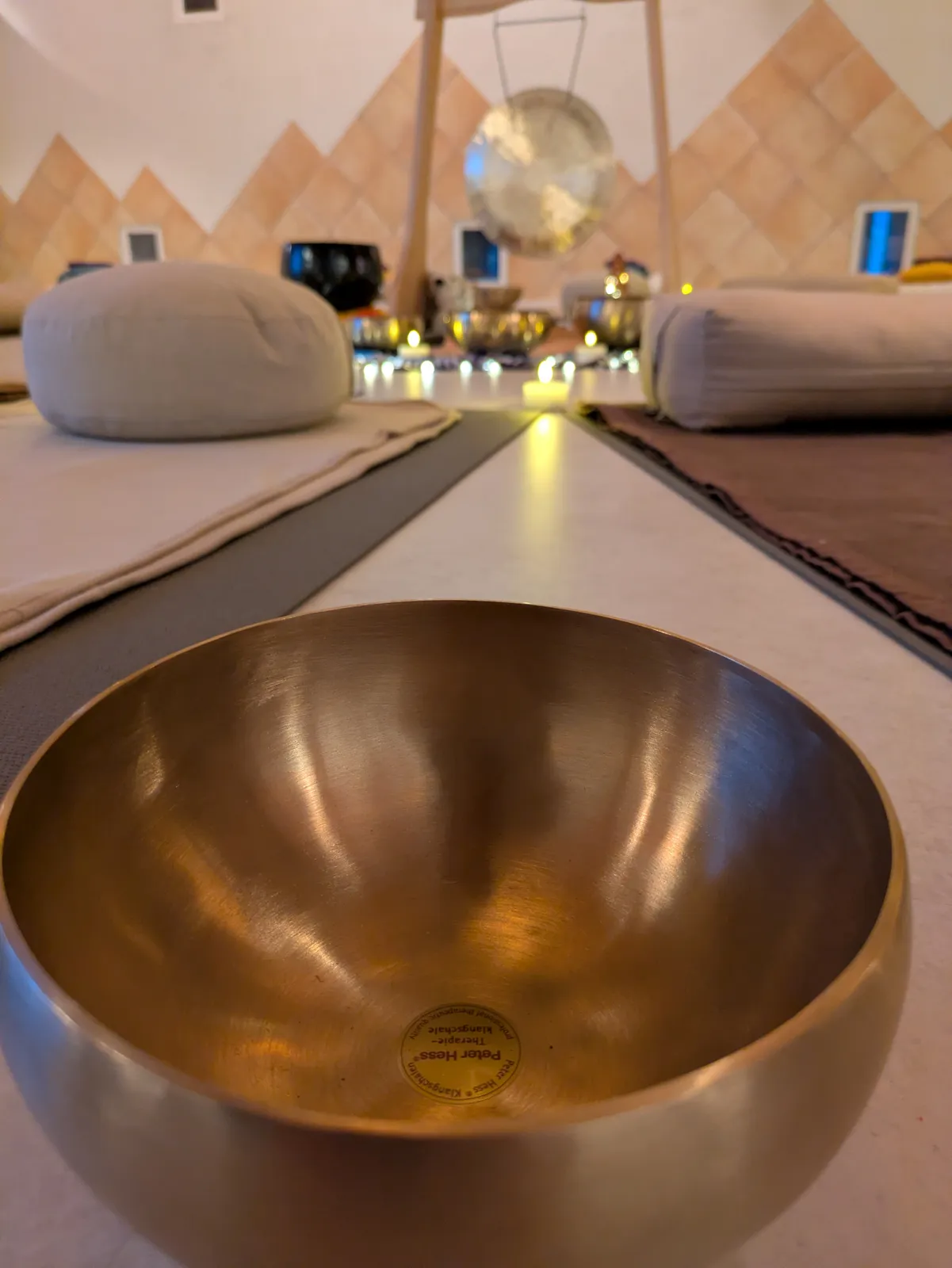 Un bol chantant au premier plan, la salle du bain sonore et le gong derrière