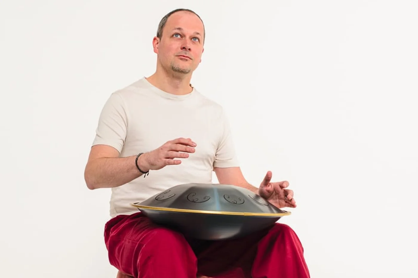 Julien assis, les mains posées sur le handpan.