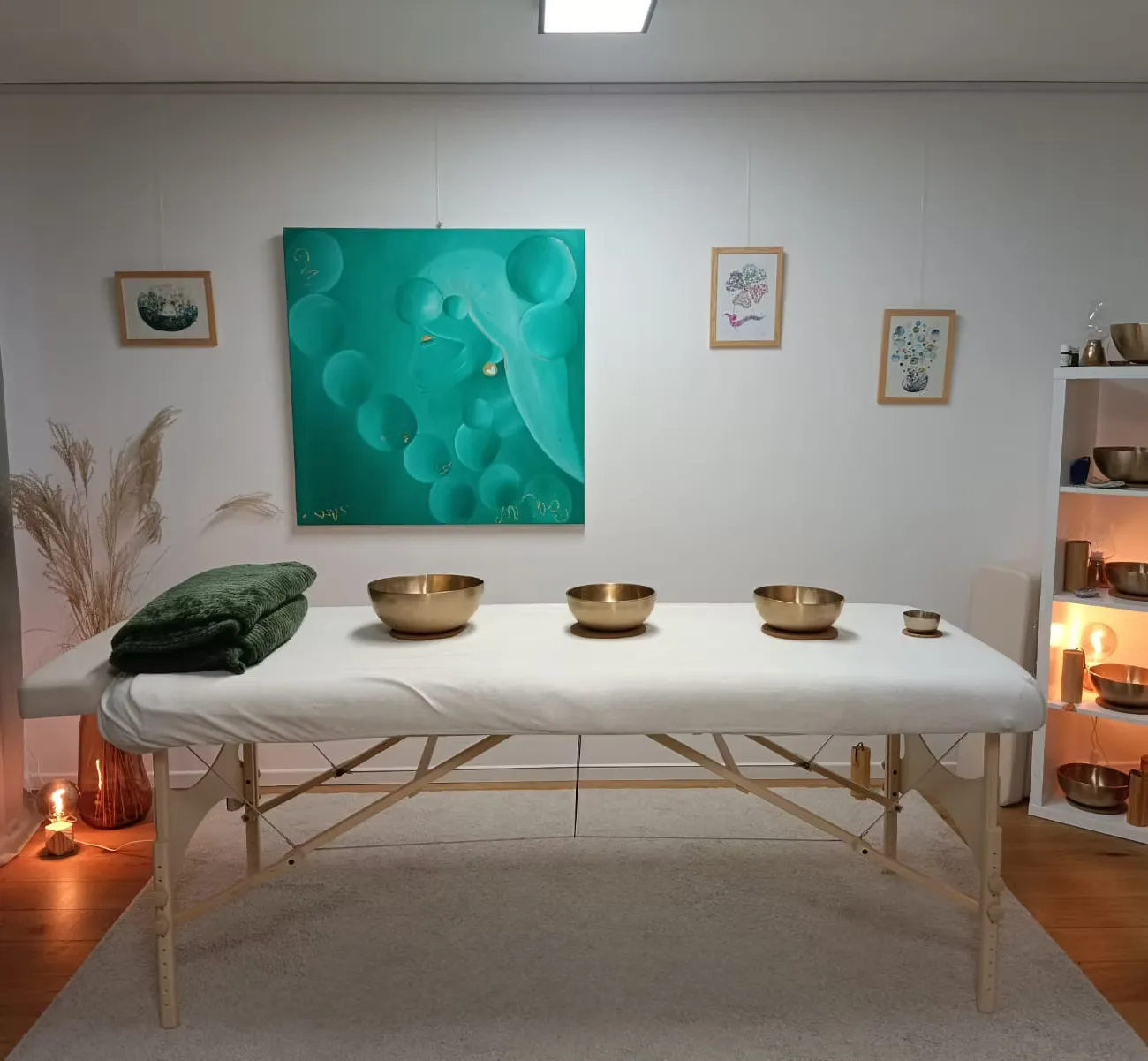 La table de massage du cabinet, préparée : les bols Peter Hess posés dessus, la lumière basse.