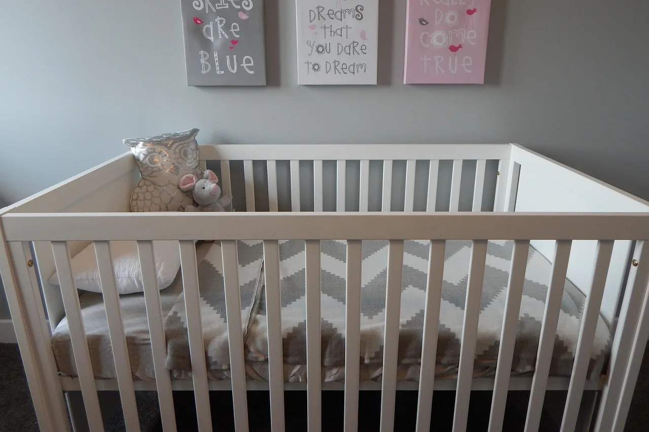 Une chambre d’enfant, lit blanc contre un mur clair