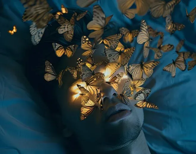 Des papillons lumineux posés sur les yeux d’un visage endormi