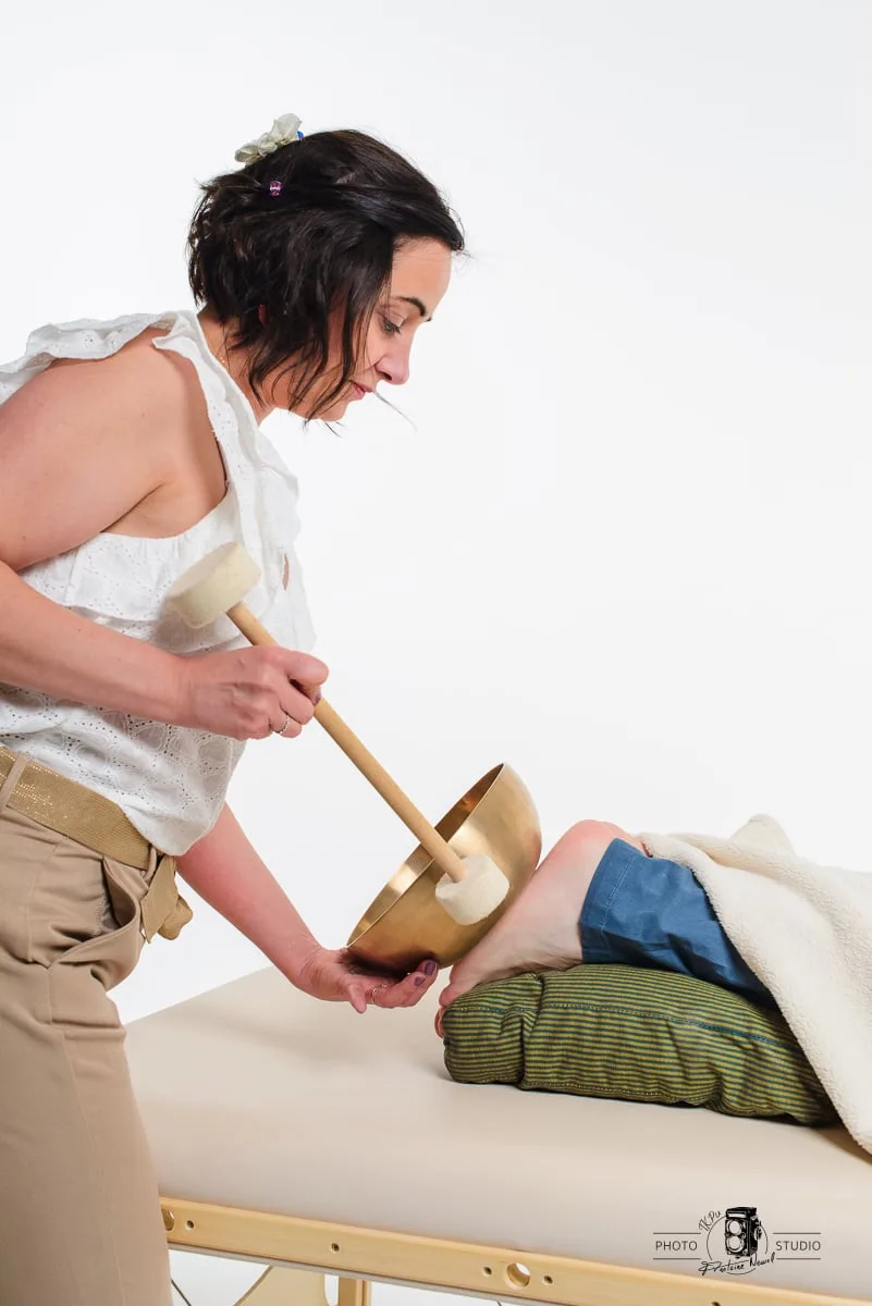 Nathalie Diaz faisant résonner le gong lors d’un bain sonore